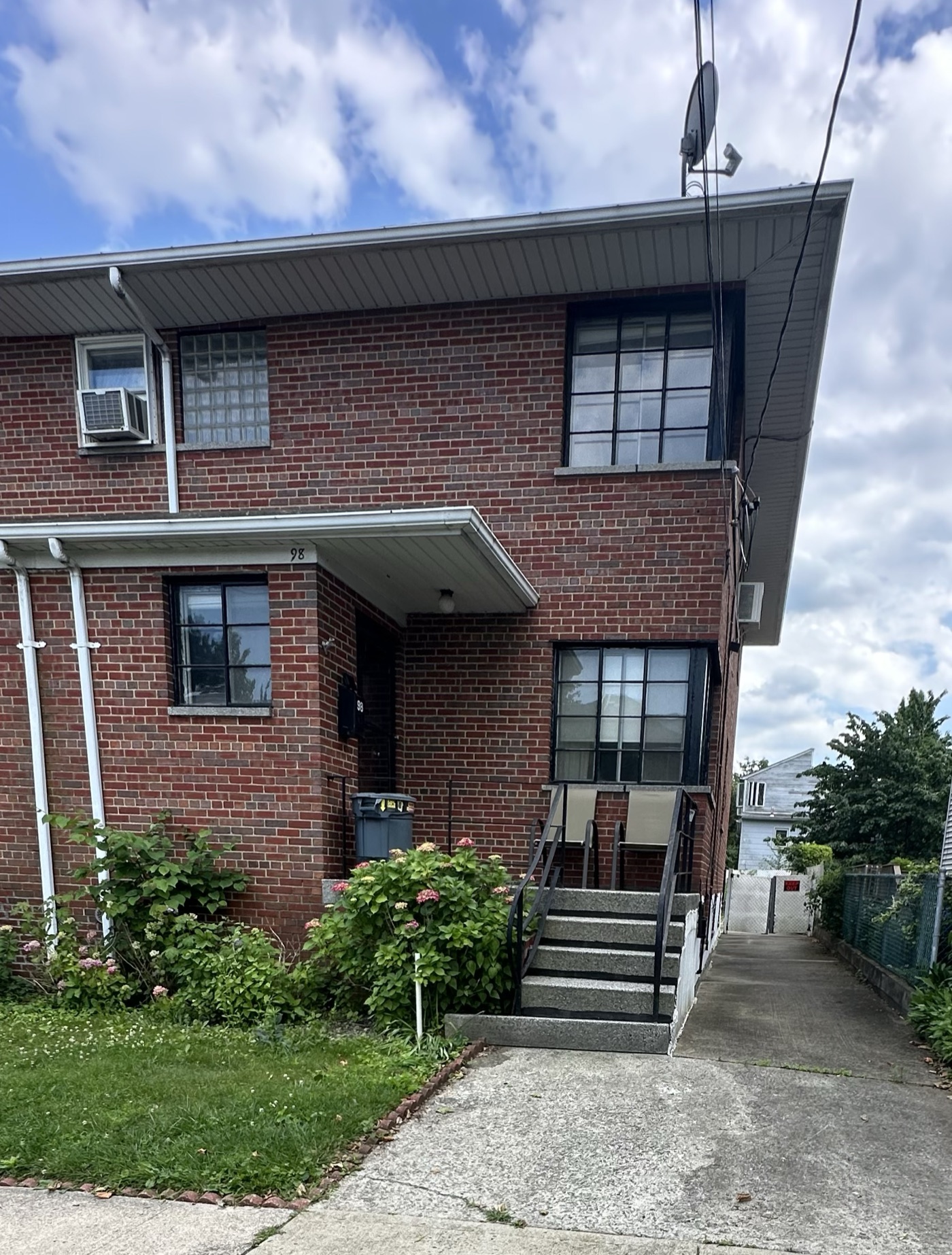 Two-family brick house with a side driveway and front steps, Bronx